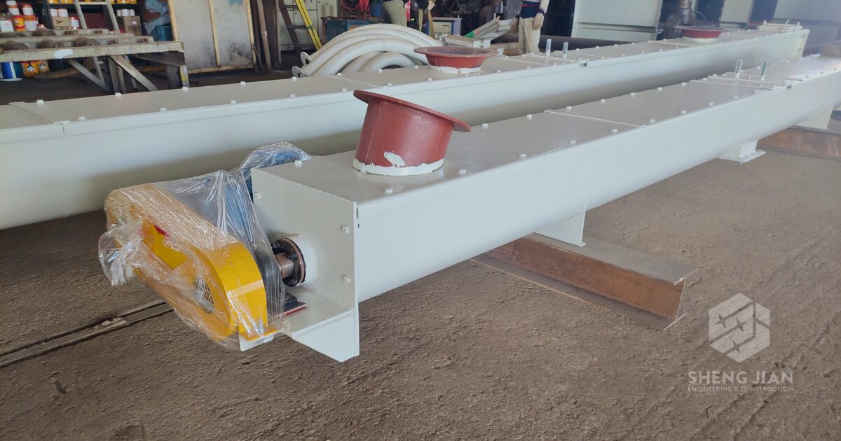 A screw conveyor moving granular materials in an industrial setting.
